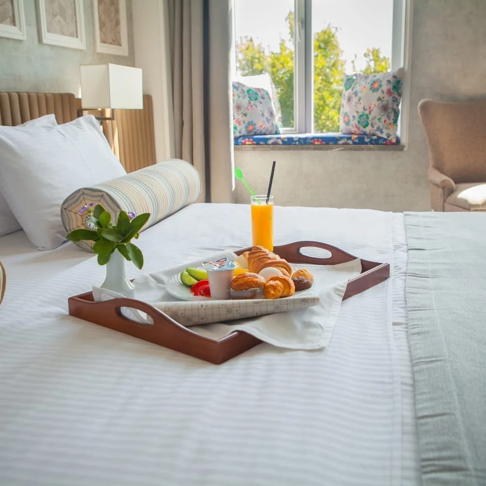 croissant boiled egg orange juice yogurt breakfast tray bed hotel room