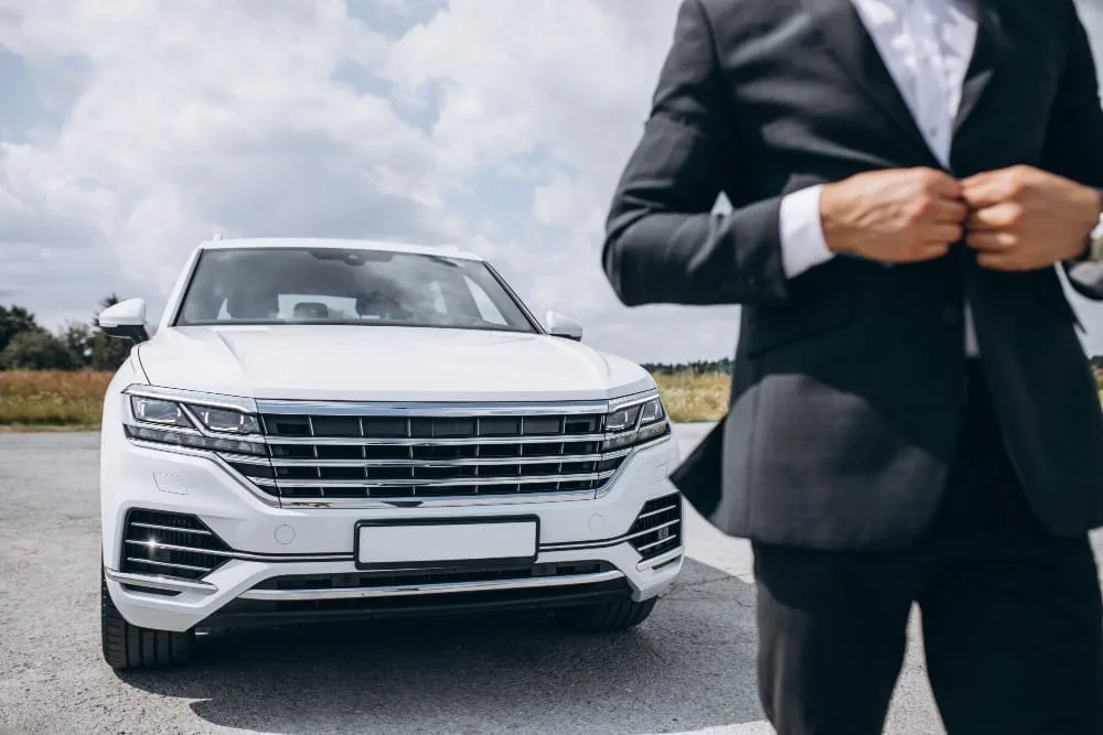 handsome business man by white car